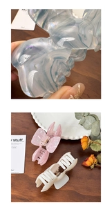 Detailed view of elegant large bow hair claw clips with marble pattern and pearly finish