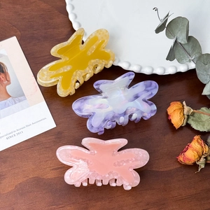 Three-piece acetate butterfly hair claws set in yellow, purple, and pink marble textures