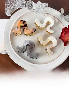 Détail de pinces à cheveux géométriques en acétate écaille de tortue, crème et gris