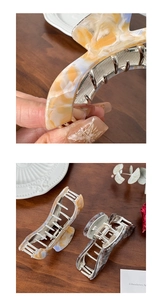 Detailed close-up of large marble resin hair claws with polished silver metal teeth