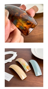 Detailed close-up of acetate spring hair clips with tortoiseshell and marble patterns