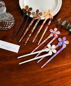 Close-up of acetic acid flower hairpins with rhinestones on a wooden background