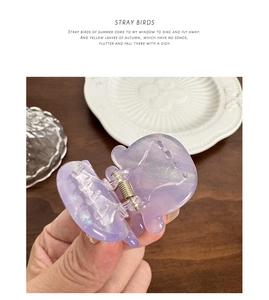 Détail d'une pince à cheveux violette en forme de pieuvre avec ressort doré