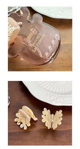 Détail de barrettes en acétate avec gravure dorée posées sur une assiette en céramique