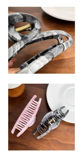 Détail d'une pince à cheveux en acétate effet marbre avec ressort doré résistant
