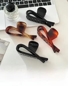 Detail of four geometric shark hair clips in matte black and tortoise shell finishes