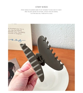 Close-up of 10cm matte charcoal grey large resin hair claw clip in hand model view