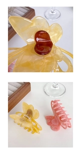 Macro detail of butterfly hair clips in amber and pink acetate with marble texture