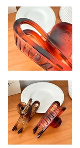Detail of amber tortoiseshell hair claws with strong golden metal springs and smooth finish