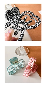 Detailed close-up of hollow acetate claw clip in black, blue and pink floral patterns
