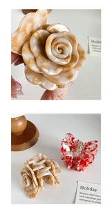 Detail einer 3D-Essigsäure-Rosen-Haarklammer mit marmorierter Textur in Bernstein und Rot