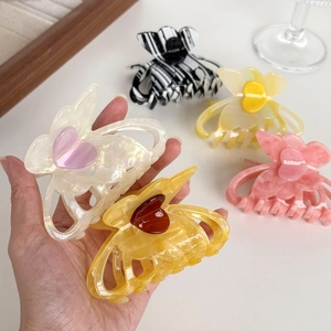 Elegant butterfly hair claws with heart accent in assorted marble acetate finishes