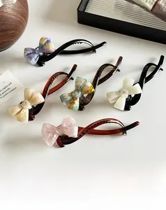 Close-up of marble pattern acetate banana clips with rhinestone bow decoration