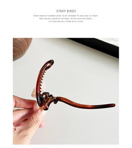 Detail view of the tortoiseshell resin bow hair clip with smooth streamlined design