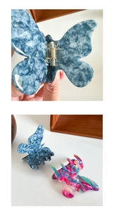 Detail von blauen und bunten Schmetterlings-Haarklammern aus Acetat mit Marmormuster