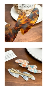Detailed view of tortoiseshell and marble texture acetate hair clips with metal base