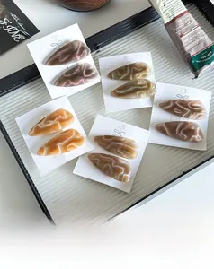 Flat lay of geometric acetate hair clips with marble texture on a decorative tray