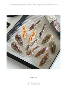 Detailed view of acetic acid hair clips in amber marble patterns on a glass tray
