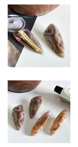 Close-up of vintage resin hair clips with cat-eye effect and golden metal ducksbill base