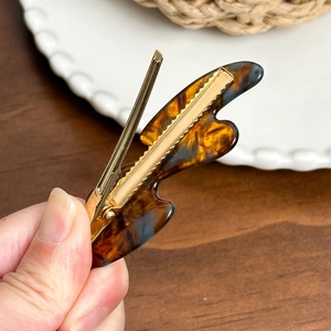 Acetate butterfly hair clip with tortoiseshell pattern and golden metal duckbill grip