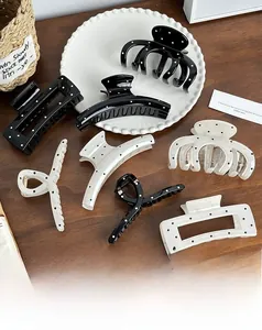 Detailed set of black and white polka dot hair claws in various geometric shapes