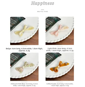 Detailed view of four acetate bow hair clips in various colors with size 6cm x 4.5cm