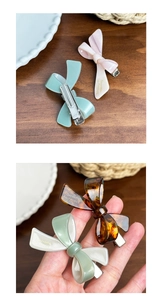 Detailed view of pastel acetate bow hair clips with silver metal alligator grip