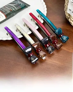 Detailed set of acetate bow hair clips in five colors with metal spring fasteners