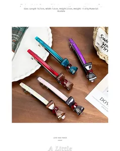 Detailed view of acetate handmade bow hair clips in five colors on a wooden table