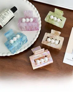 Détail de pinces à cheveux carrées en acétate avec perles en divers coloris marbrés