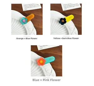Detail showing three colors of acetate flower hair clips with France Handmade lettering