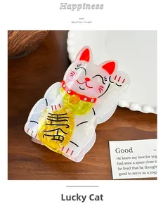 Dettaglio macro della molletta Maneki Neko in acetato con strass su base in legno