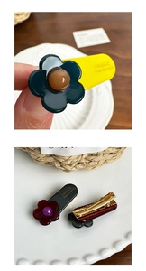 Detail of floral resin hair clips with handmade logo and golden duckbill metal base