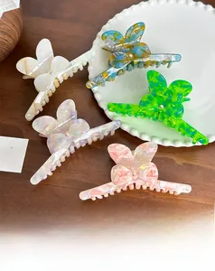 Detail of five colorful butterfly hair claws with marble textures and rhinestone accents