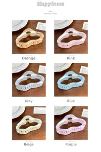 Détail de pinces à cheveux aux couleurs bonbon en six tons pastels sur fond en bois