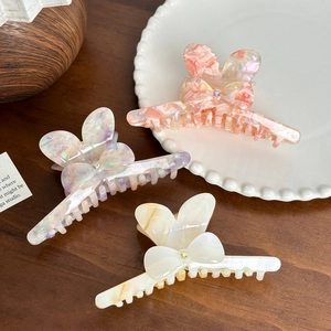 Elegant marble pattern acetate hair claws with bow shapes and subtle rhinestone accents