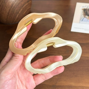 Set de pinces à cheveux ondulées en champagne et blanc crème sur table en bois