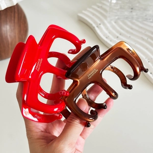 Pinces à cheveux artisanales rouges et ambre en acétate avec logo doré haut de gamme