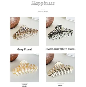 Macro detail of large acetate claw clips in four colors with elegant pearl embellishments
