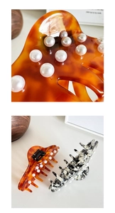 Macro detail of tortoiseshell and marble hair claws with embedded white faux pearls