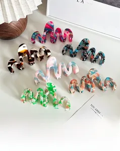 Dettaglio di 6 mollette per capelli in acetato colorato con motivi marmorizzati e onde