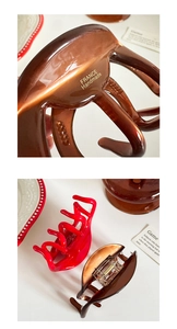 Detail showing high-gloss acetate hair claw clips with France Handmade gold engraving