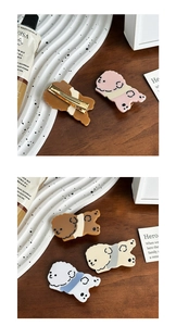 Detail of four colorful acetate puppy hair clips with gold metal duckbill fasteners