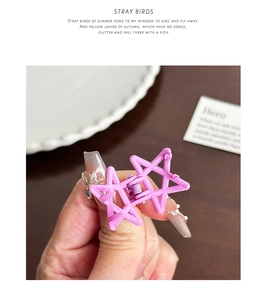 Close-up of a matte purple star-shaped mini hair claw clip held in hand for detail