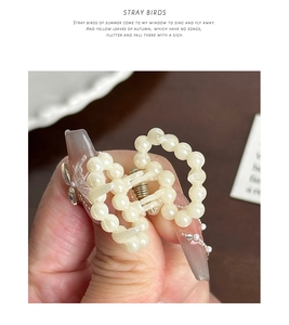 Gros plan sur la mini pince à cheveux en perles élégantes avec perles blanc crème