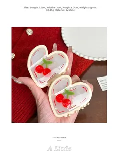 Detail view of heart-shaped acetate claw clips with cherry pattern measuring 7.5cm long
