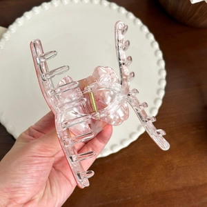 Pink translucent bear hair claw clip with pearlescent resin finish and gold spring detail
