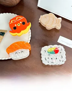 Detail of acetate hair clips featuring sushi and octopus shapes on a ceramic plate