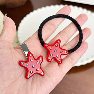 Set barrette et élastique étoile rouge avec strass colorés sur une assiette déco