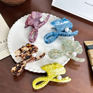 Cinq pinces à cheveux ginkgo de couleurs variées avec perles sur une assiette en céramique
